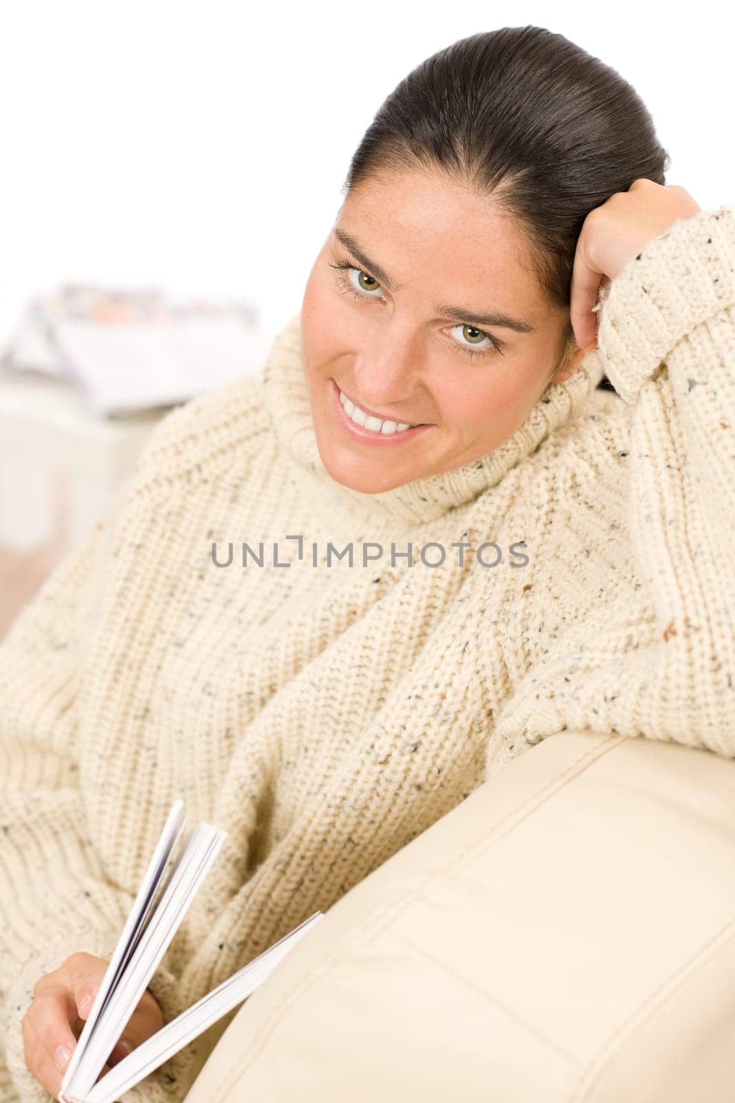 Happy mid-aged woman read book sitting on couch