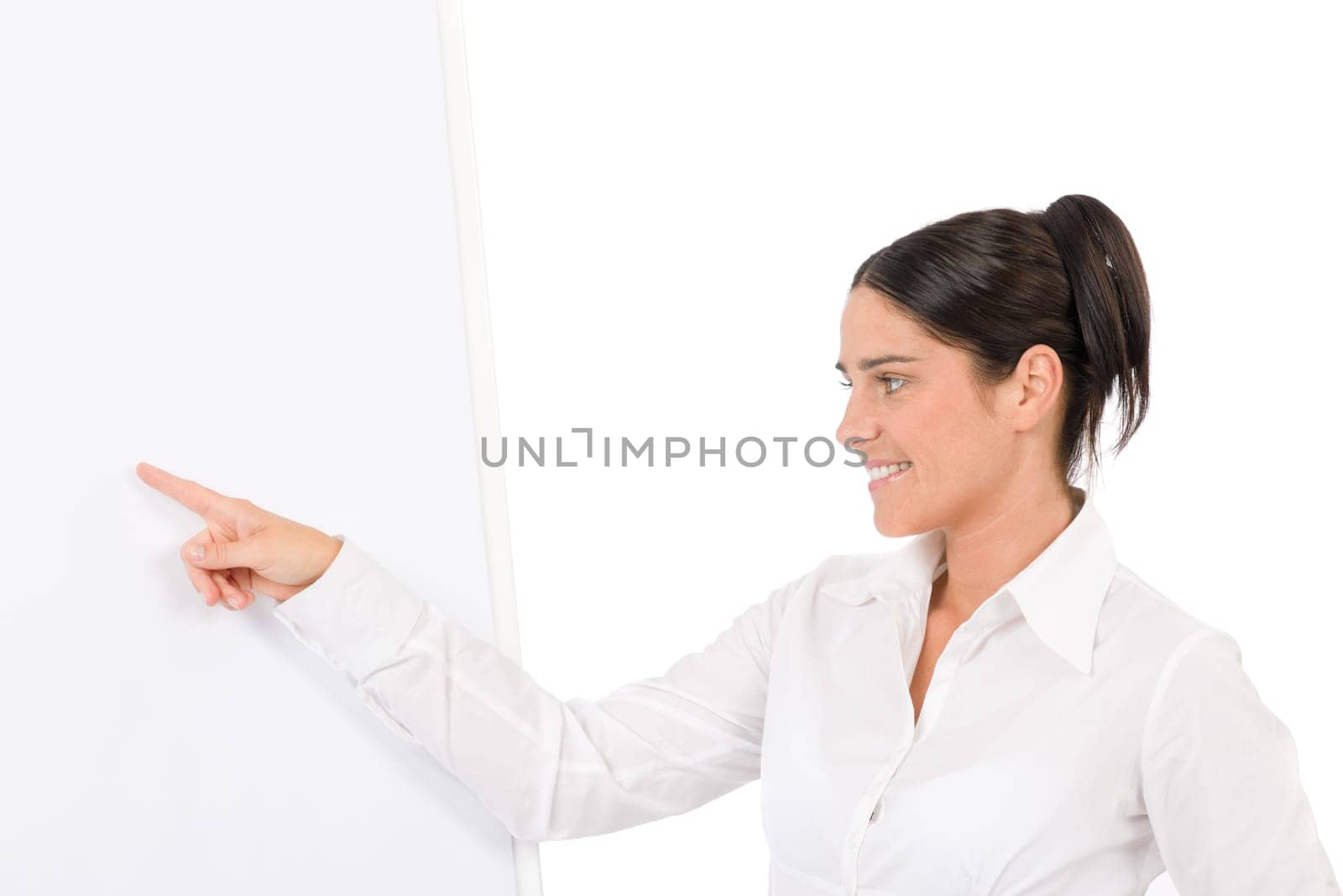 Happy businesswoman pointing at empty flip chart on white