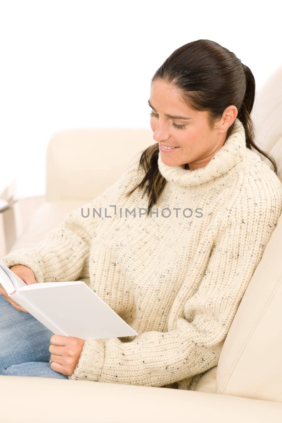 Happy mid-aged woman read book sitting on couch