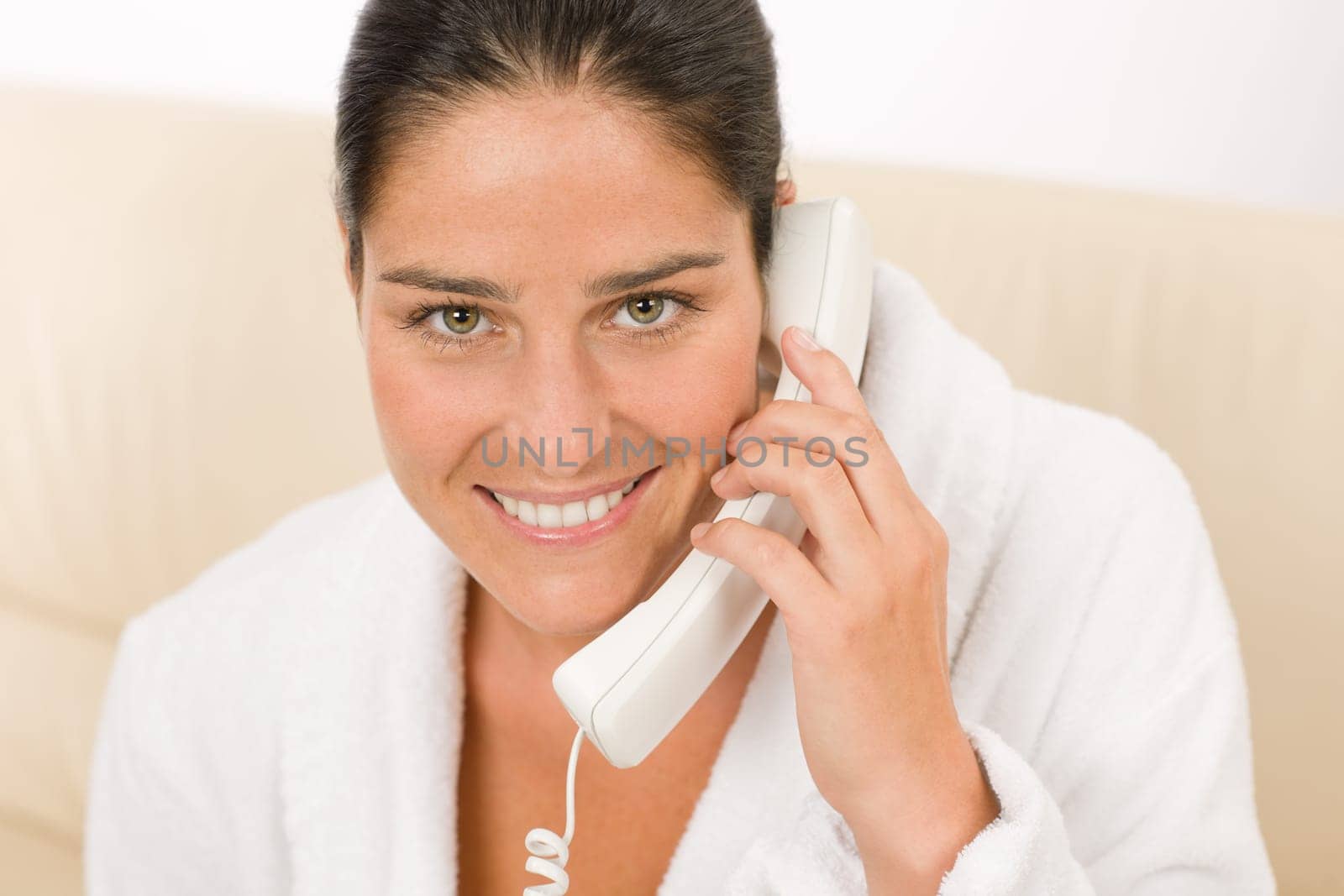 Portrait of attractive mid-aged woman speaking on phone wear bathrobe