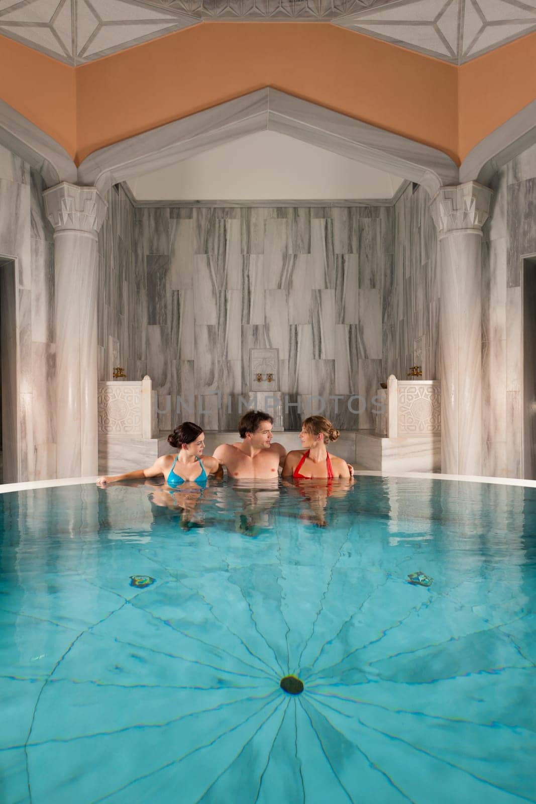 Three friends in the indoor pool or thermal bath