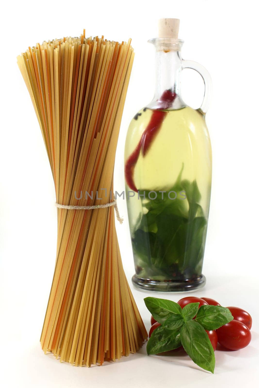 Spaghetti and herb oil against white background