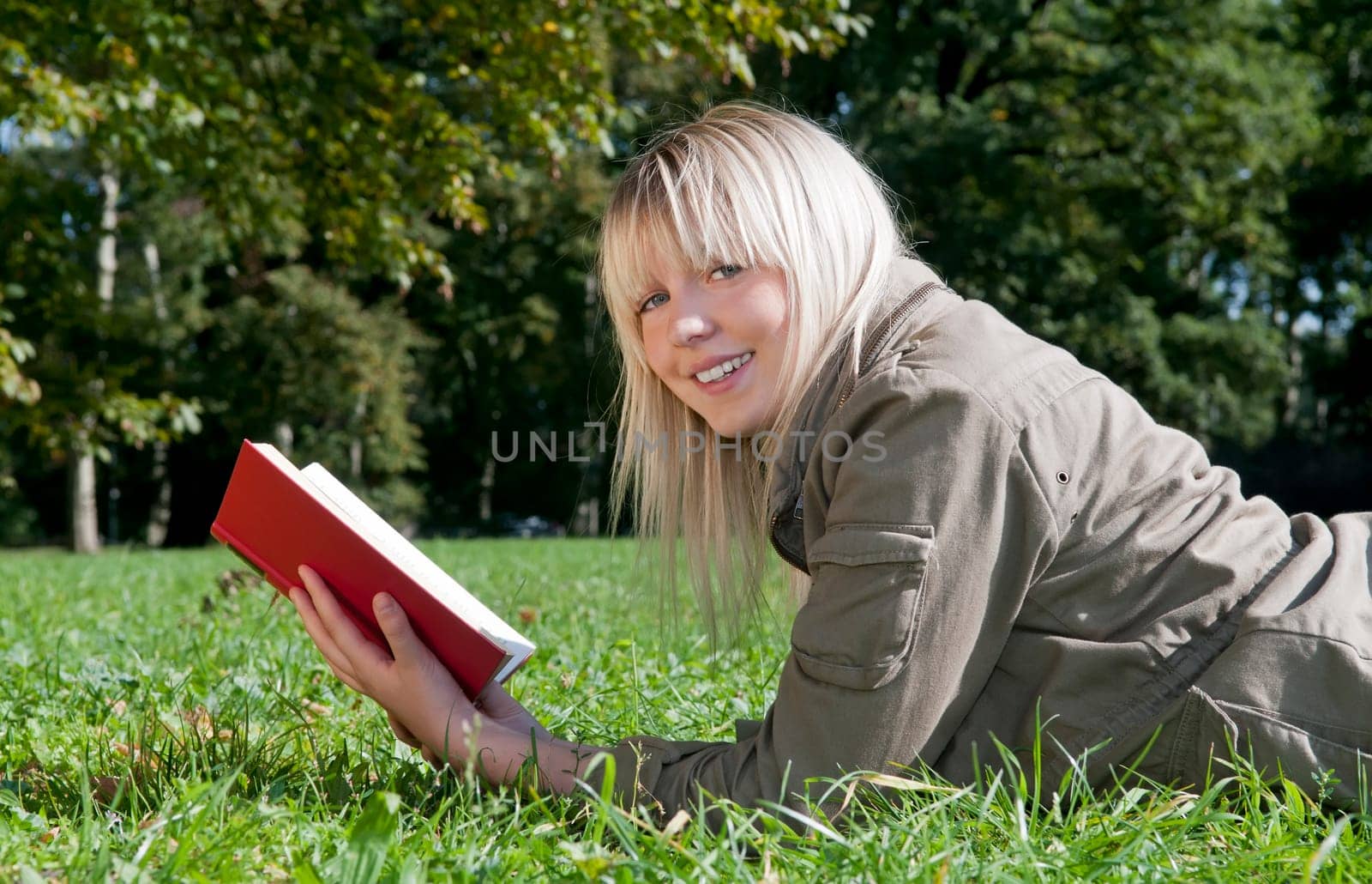 Young woman reading book in a meadow