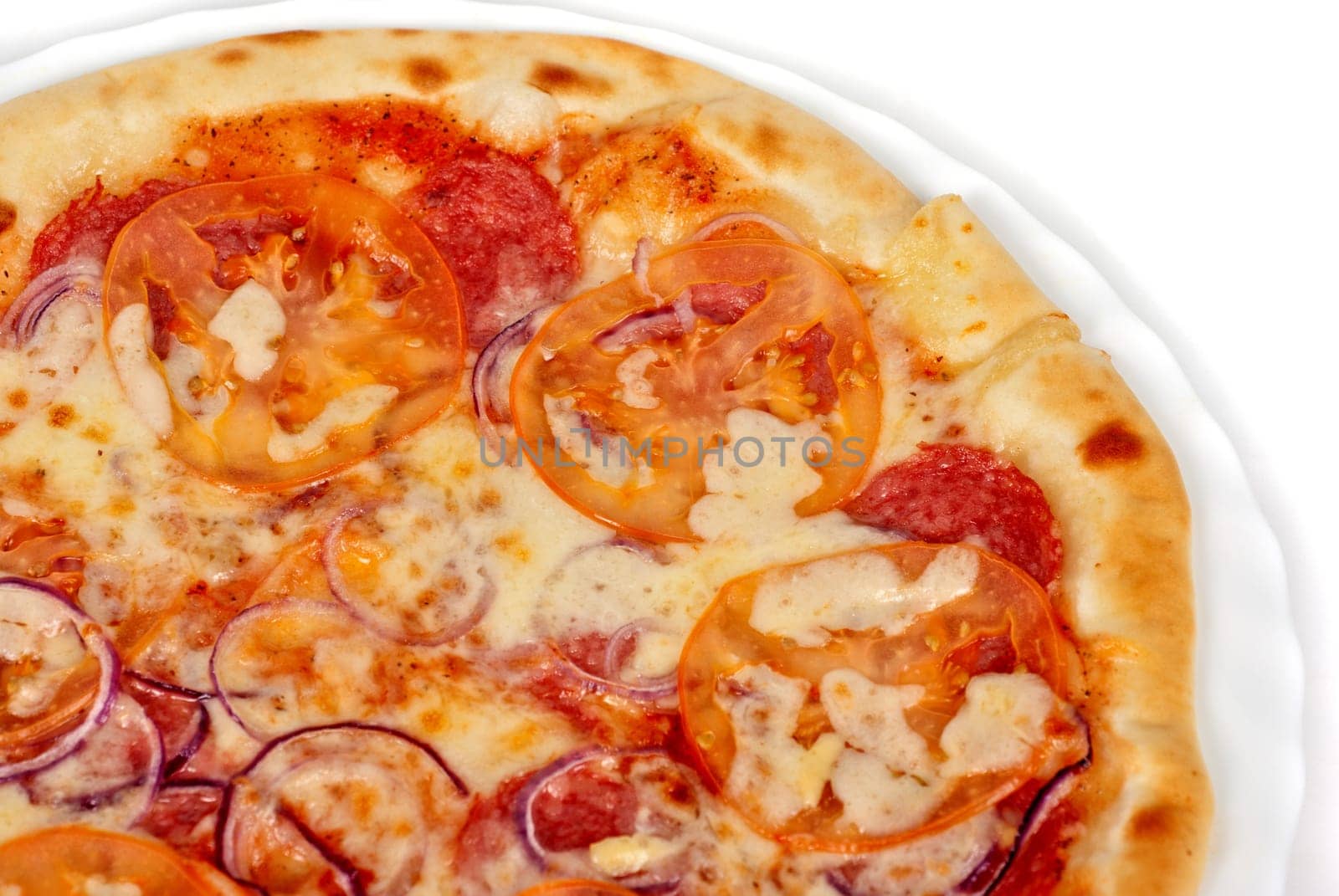 pizza closeup with salami, tomato, onion and mozzarella cheese
