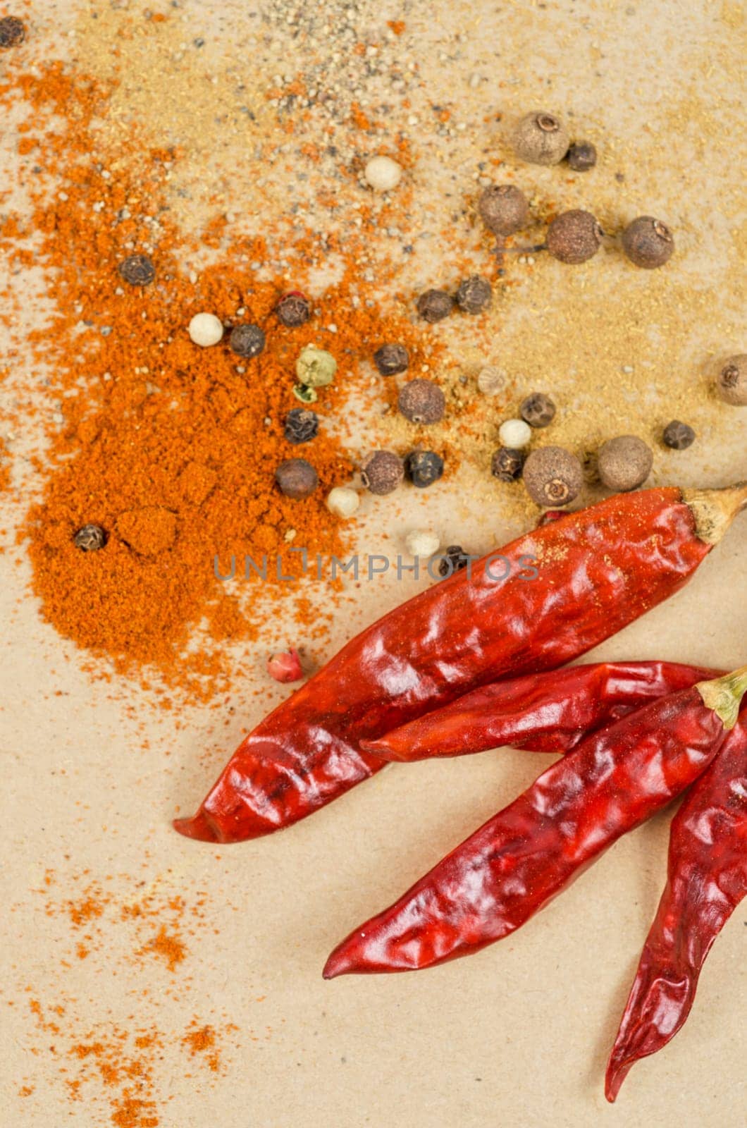 dried peppers and other kind of peppers spices on a brown background