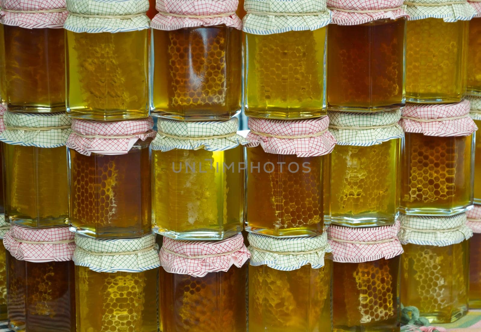 Jars of honey, arranged in a colorful, with the cells.