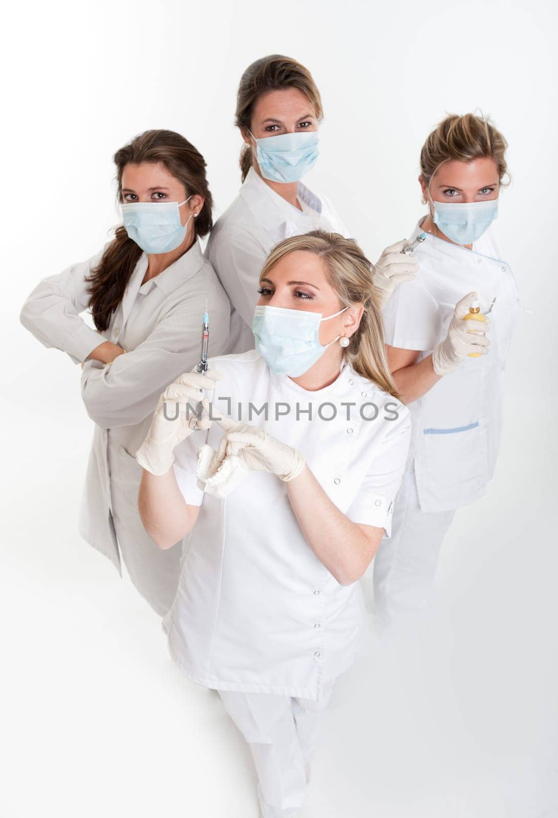 Four female dentists posing with masks and equipment