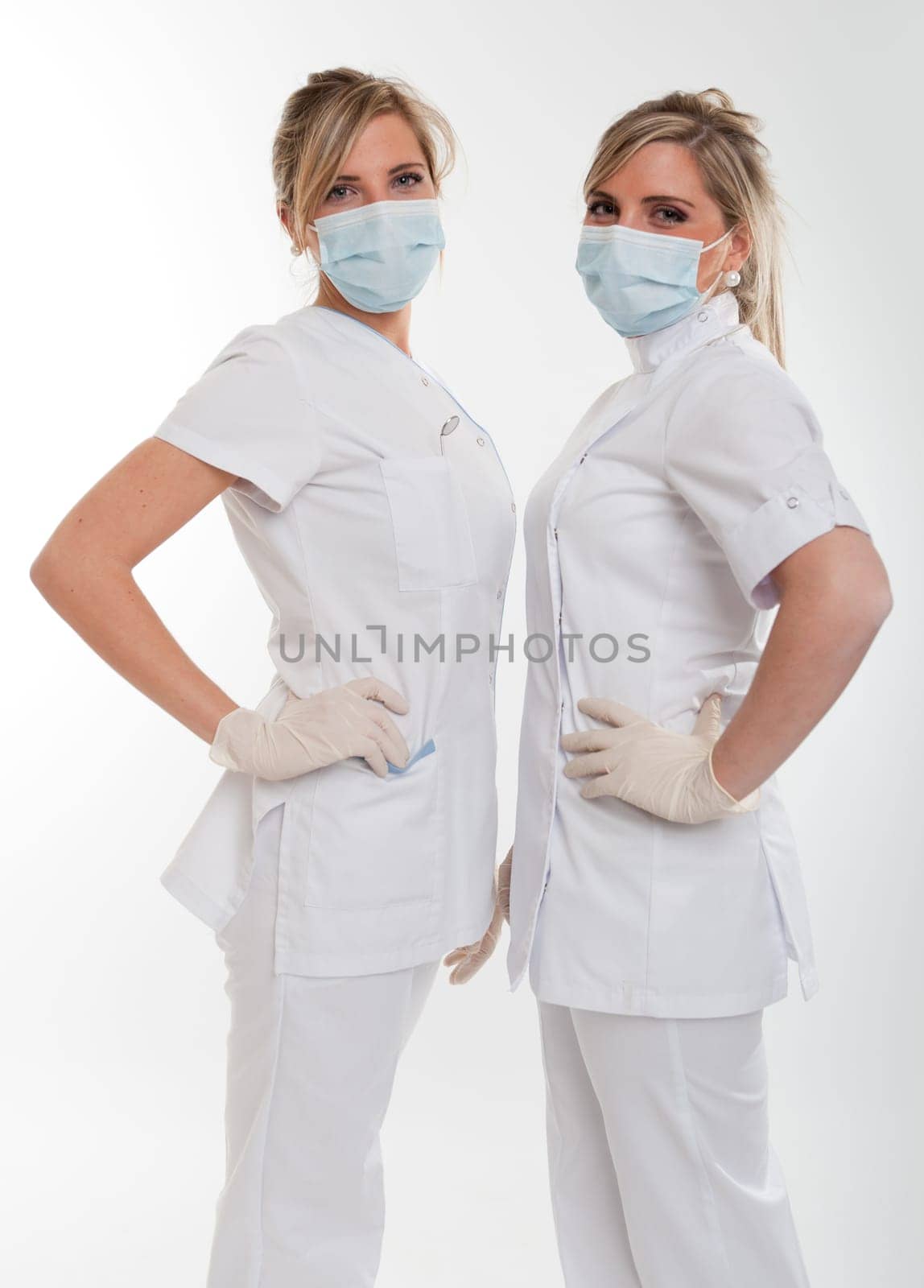 Two young female dentists posing with uniform and mask