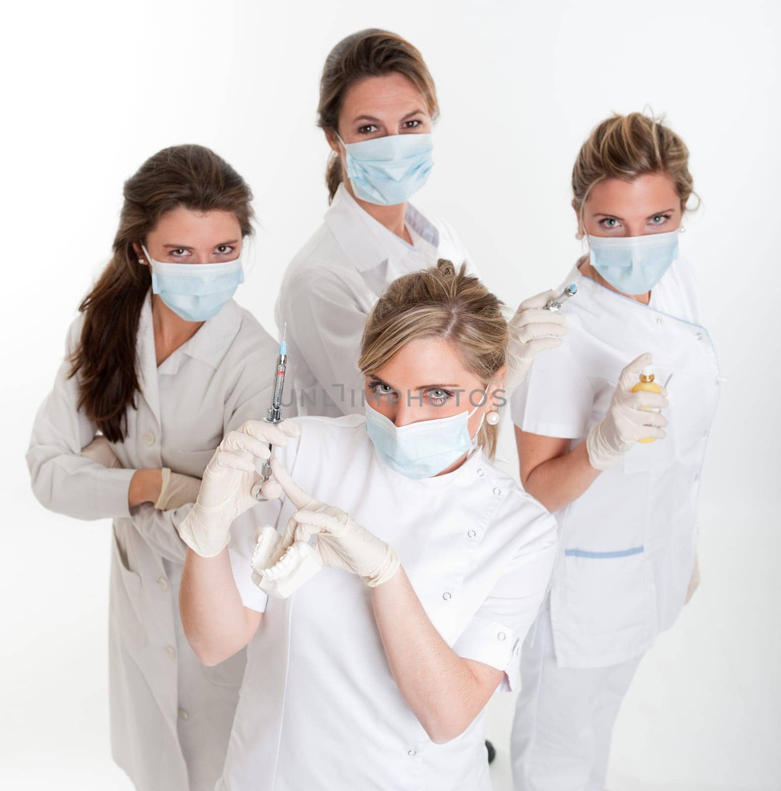 Four female dentists posing with masks and equipment