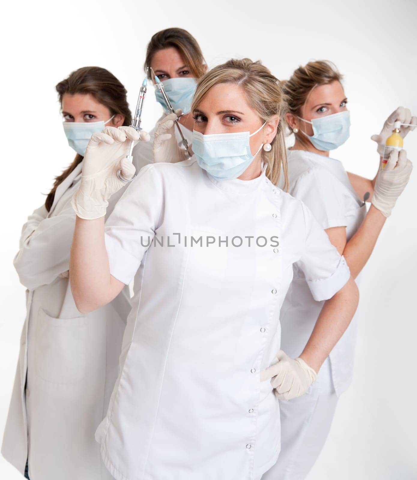 Four female dentists posing with masks and equipment