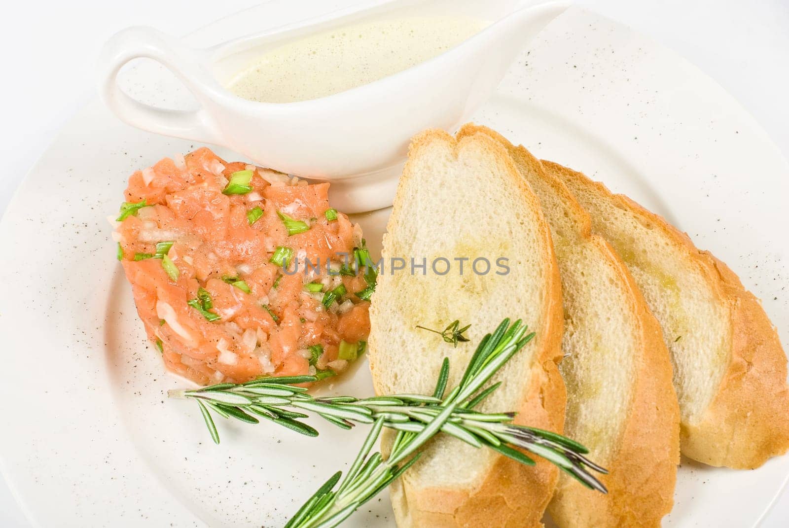 Tar-tar from salmon fish with green onion. Served with honey sauce and white bread toast.
