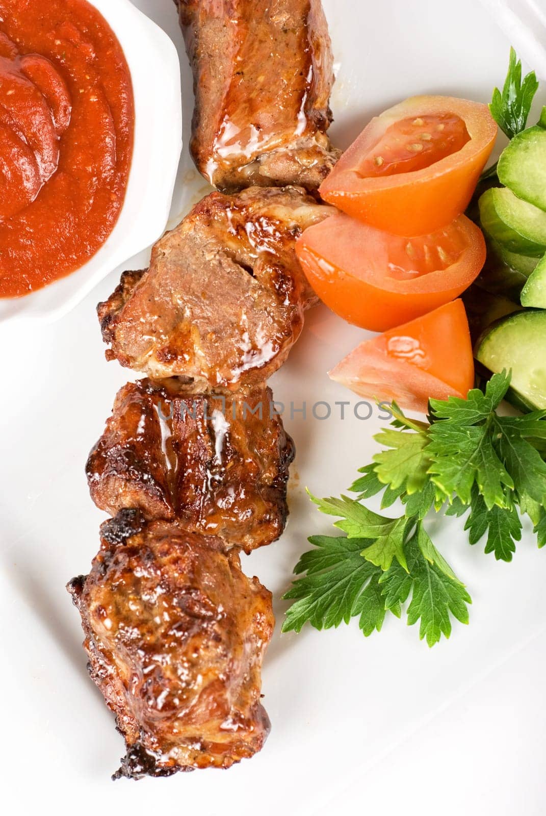 Fried kebab meat with vegetables and sauce