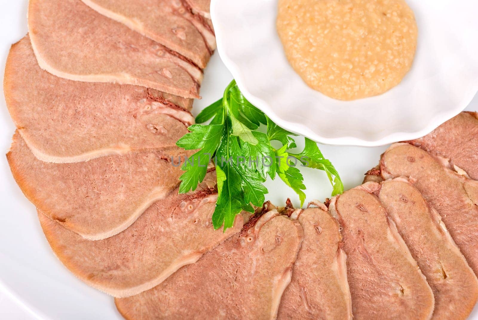 Beef tongue with closeup on a white plate