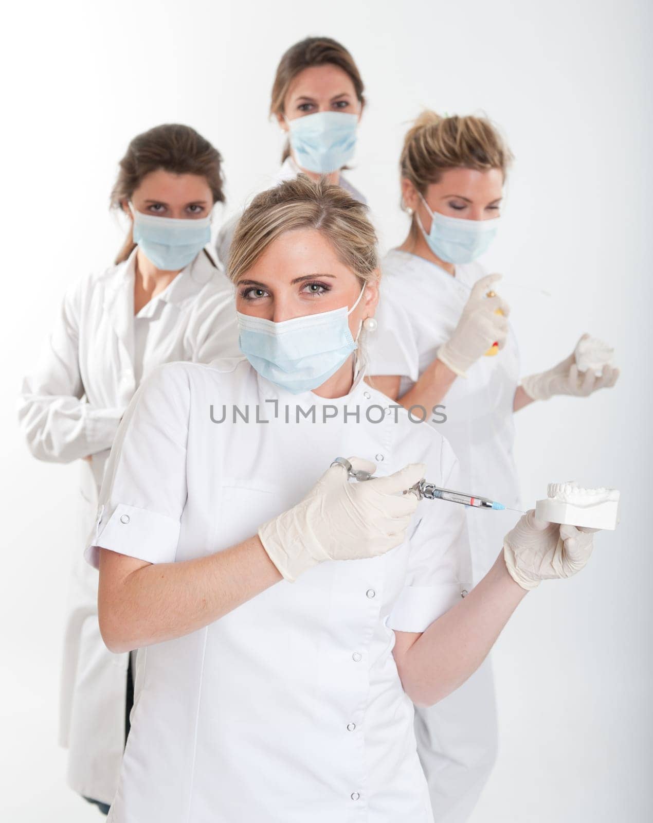 Four female dentists posing with masks and equipment
