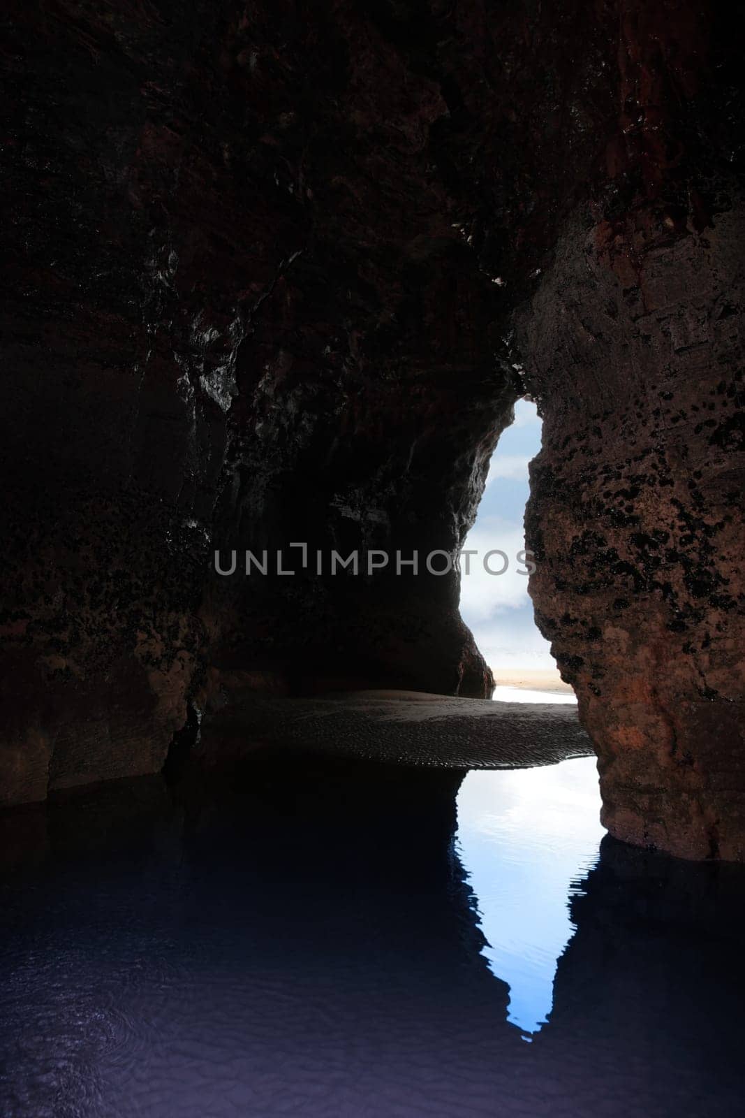 a view from the inside of a beach cave looking out at the sea