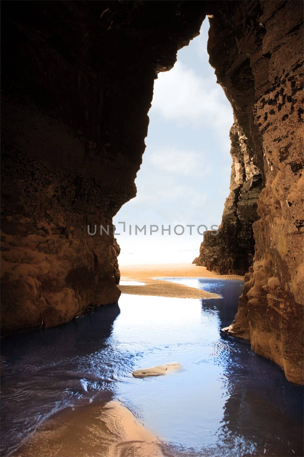 a view from the inside of a beach cave looking out at the sea