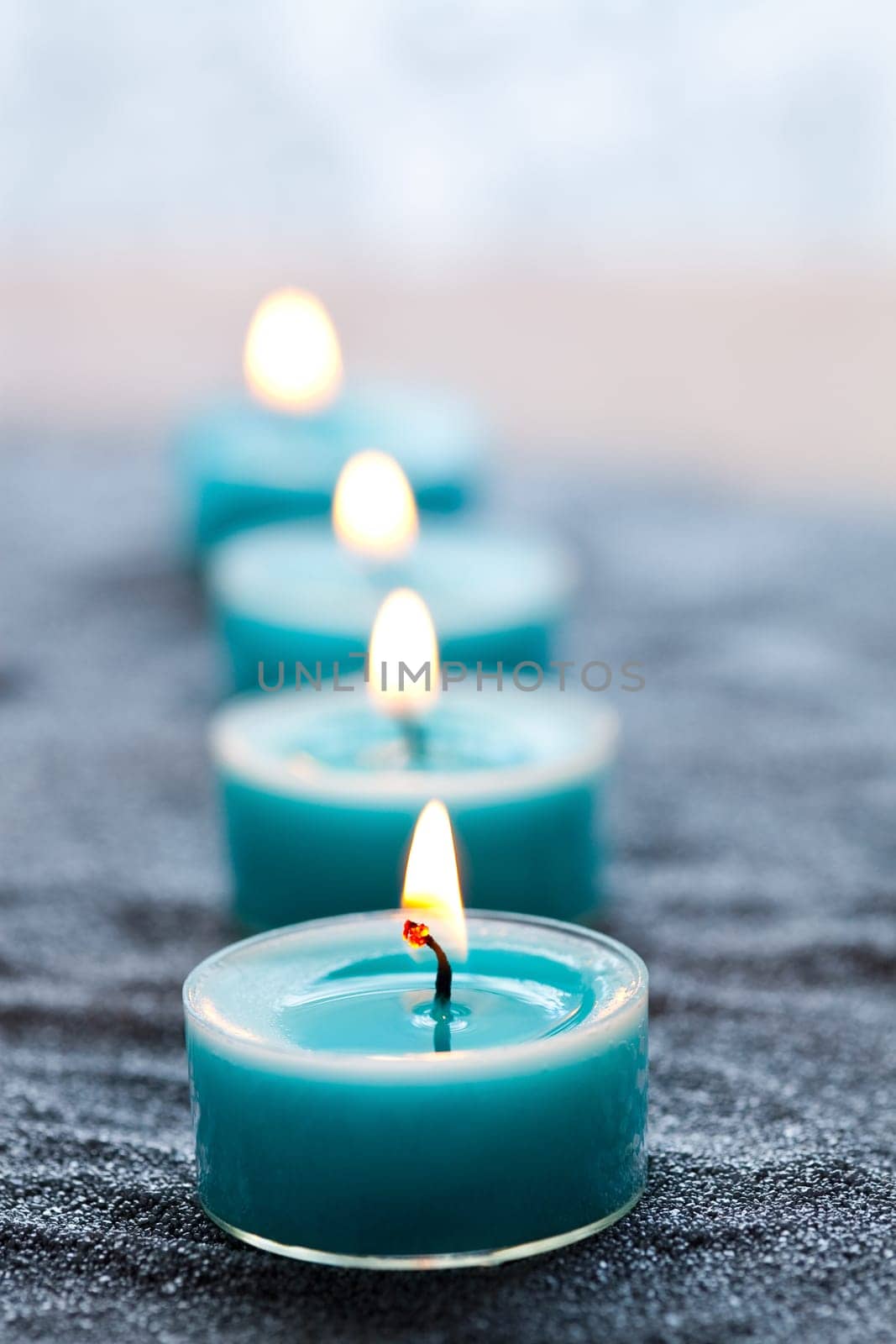 Close-up of blue candles on silver sand