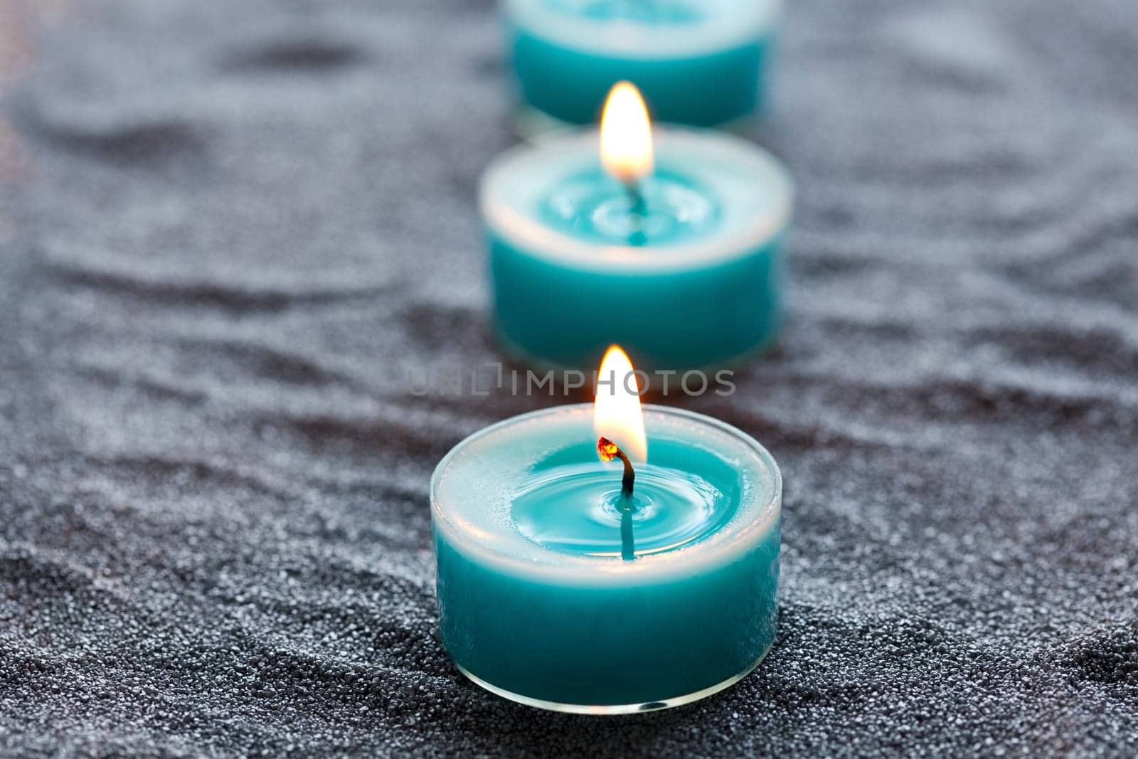 Close-up of blue candles on silver sand