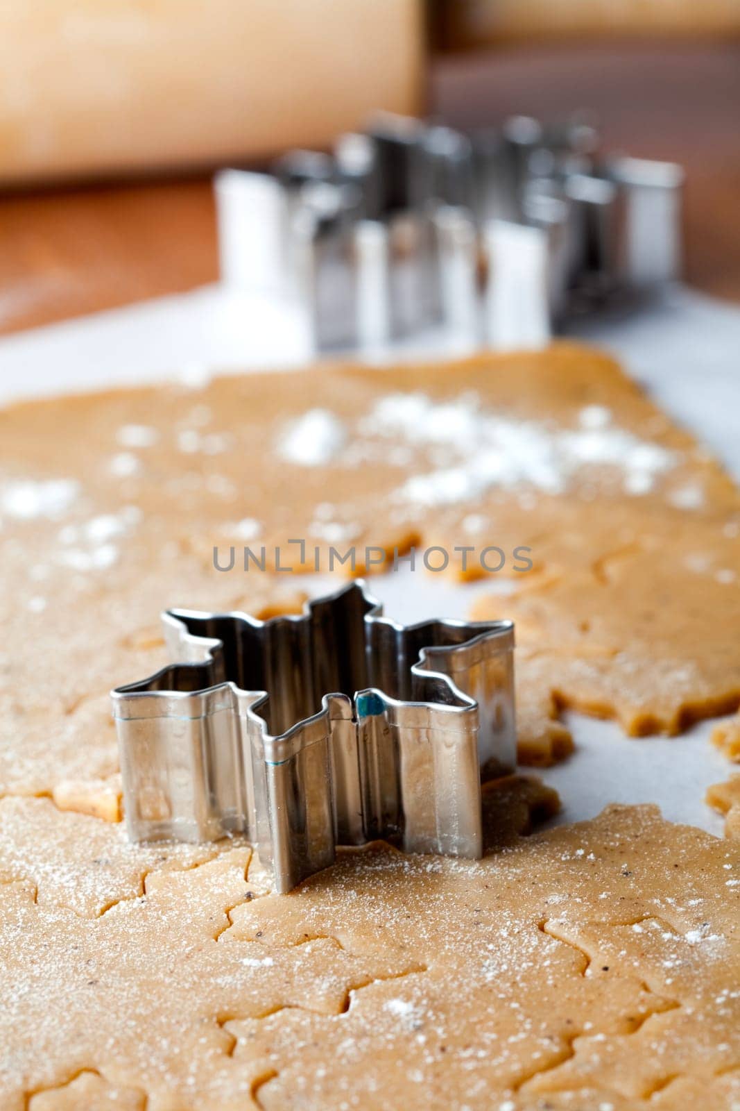 Making gingerbread cookies for Christmas. Gingerbread dough with star shapes and a cutter.