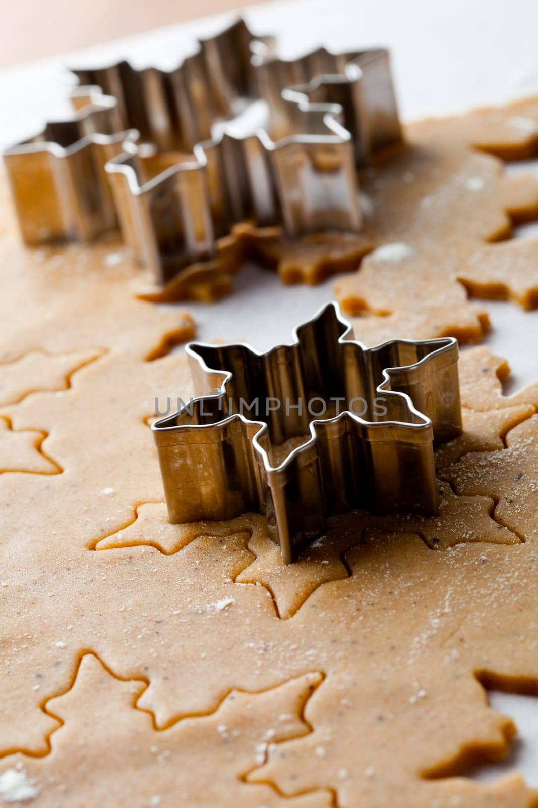 Making gingerbread cookies for Christmas. Gingerbread dough with star shapes and a cutter.