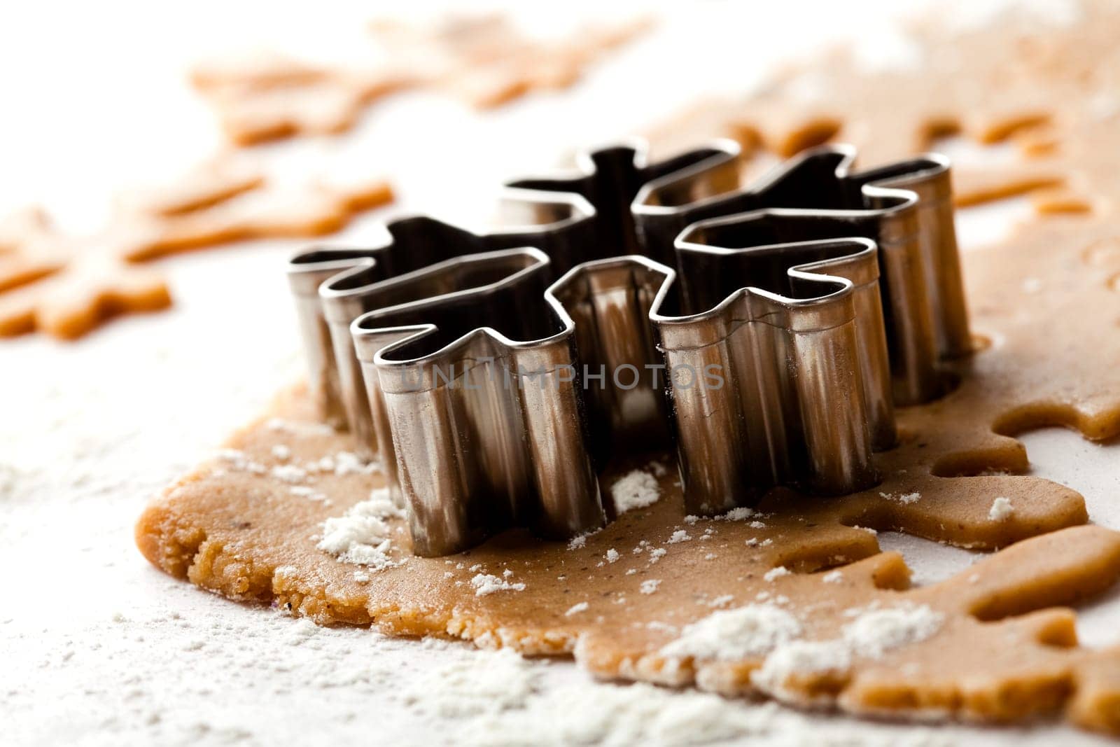 Making gingerbread cookies for Christmas. Gingerbread dough with snowflake shapes.