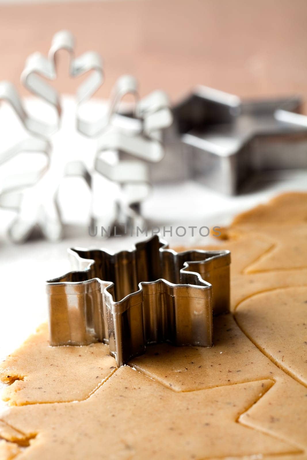 Making gingerbread cookies for Christmas. Gingerbread dough with star shapes and a cutter.
