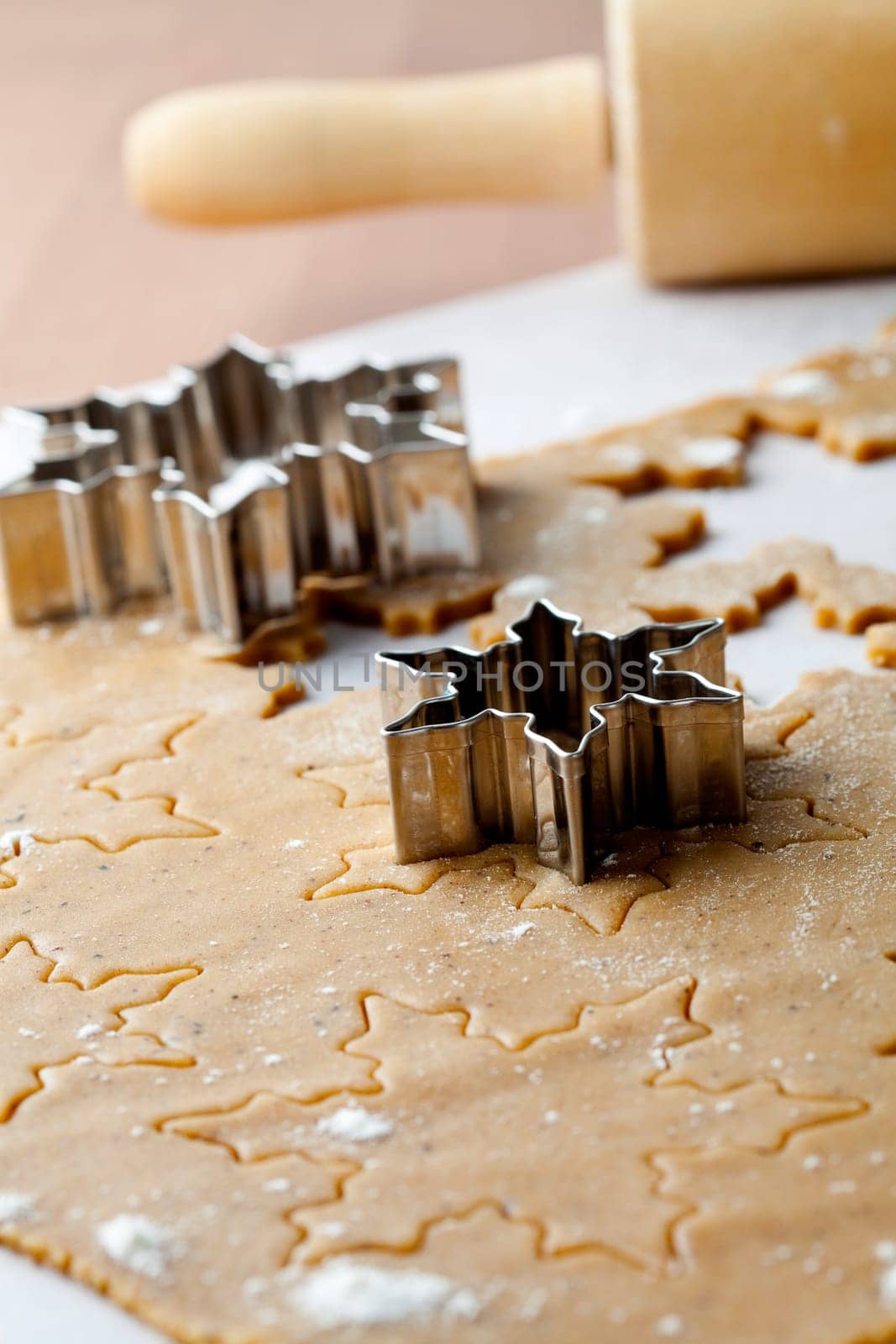 Making gingerbread cookies for Christmas. Gingerbread dough with star shapes and a cutter.