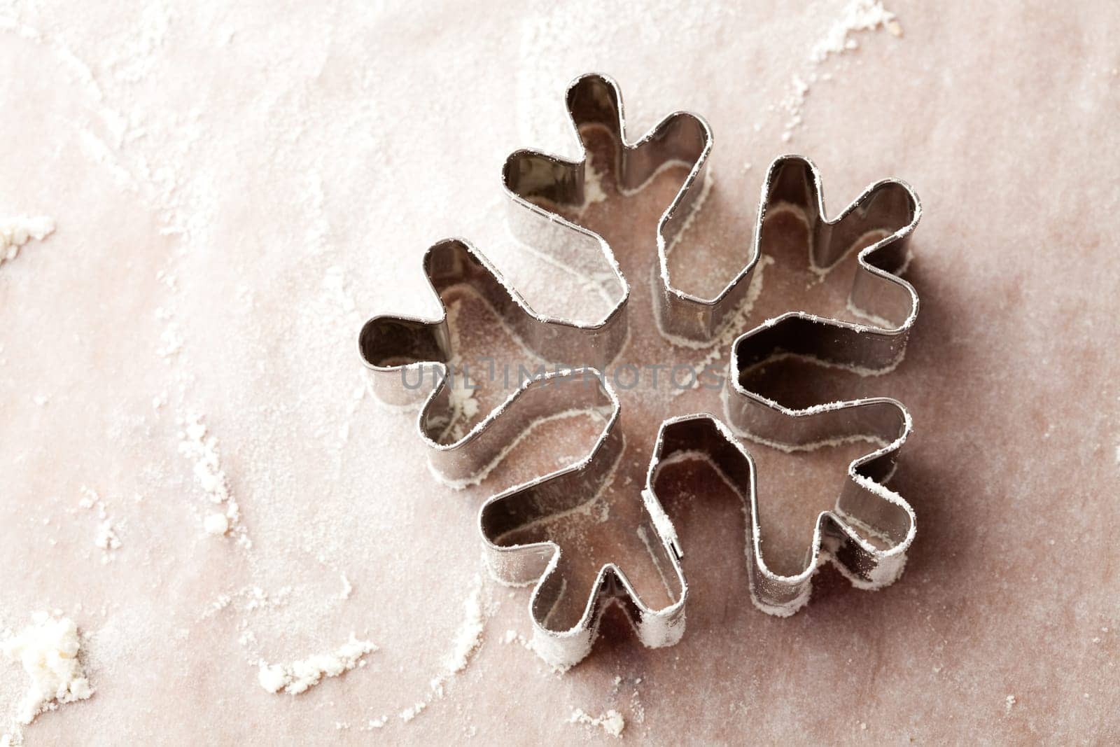 Close-up of a snowflake gingerbread cutter with flour.