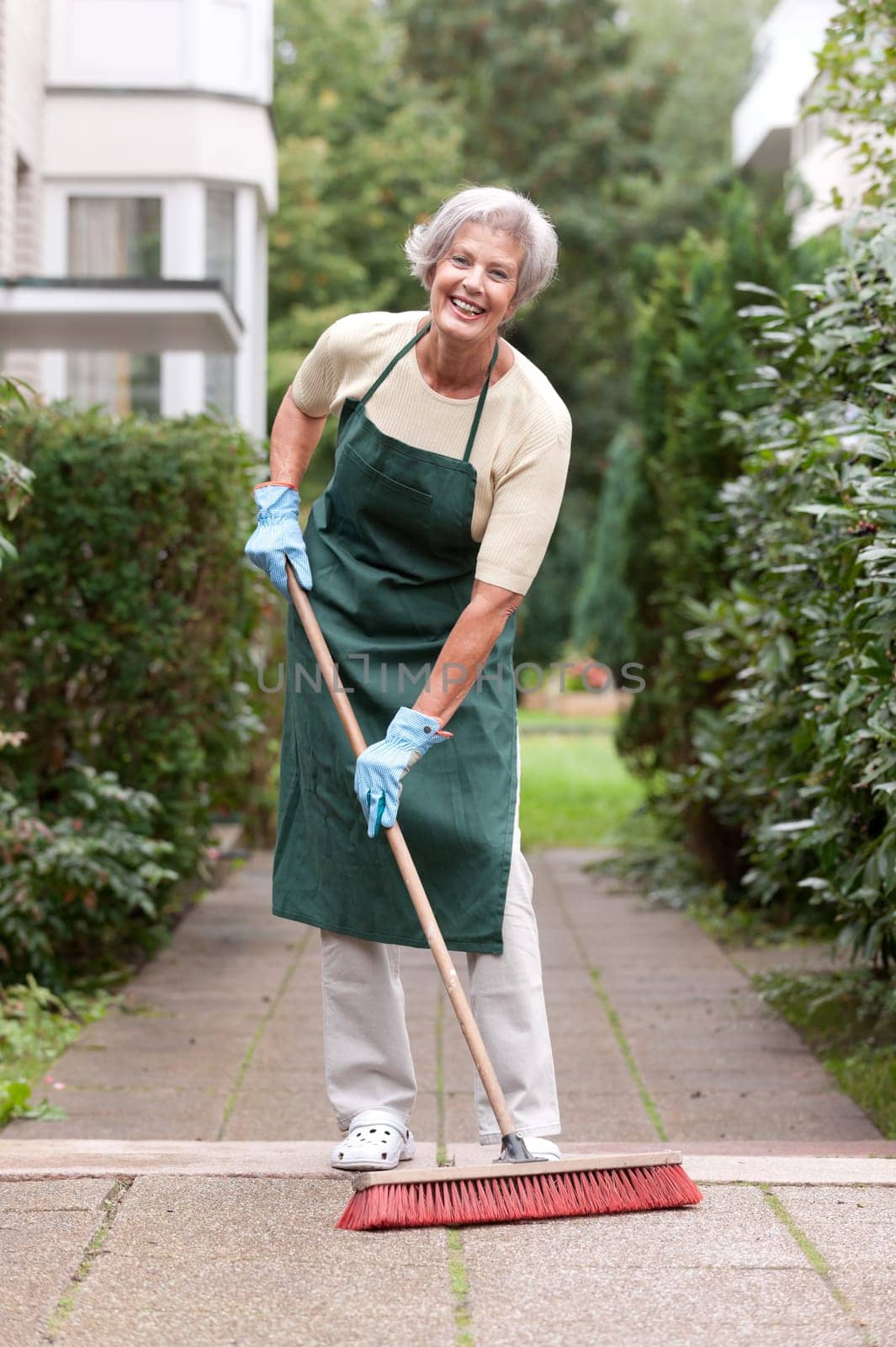 Active senior woman with a broom