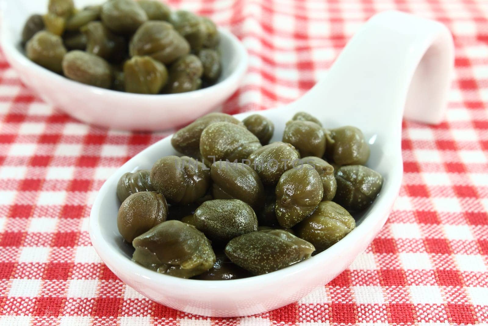 pickled capers on a white spoon
