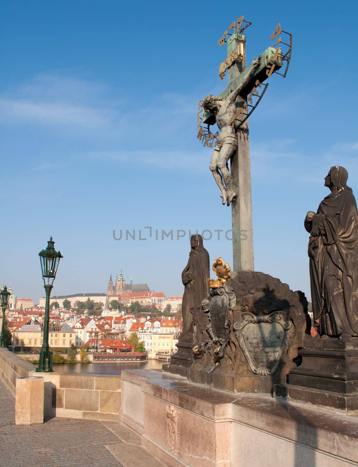 Statue of Jesus on Charles Bridge - Prague Castle in Background, Czech Republic