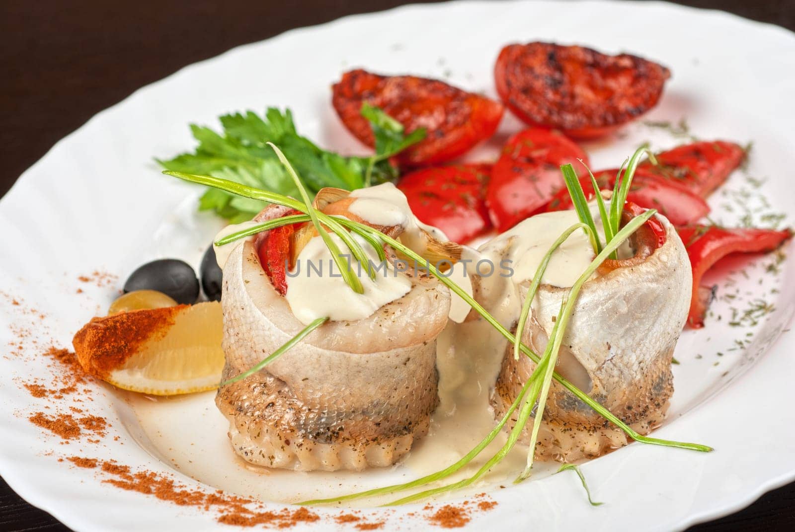 fillet of pikeperch stuffed with trout fish with baked pepper, tomato and leek