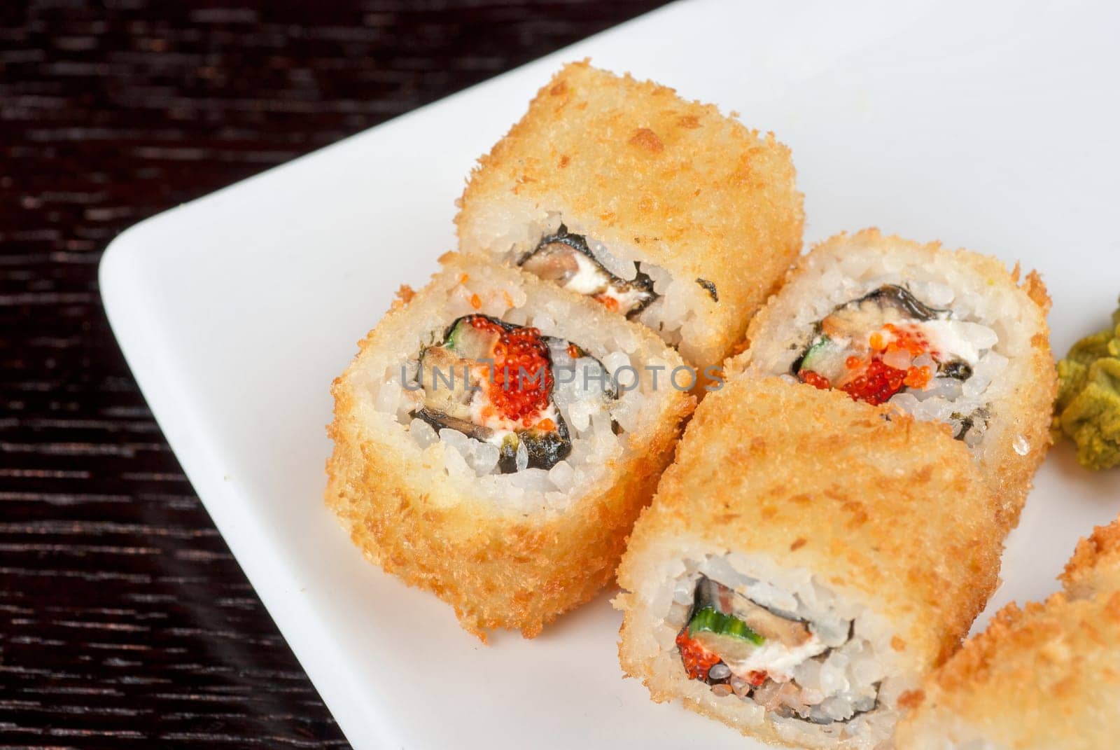 Sushi rolls made of rice, smoked eel, cream cheese and flying fish roe - tobiko caviar