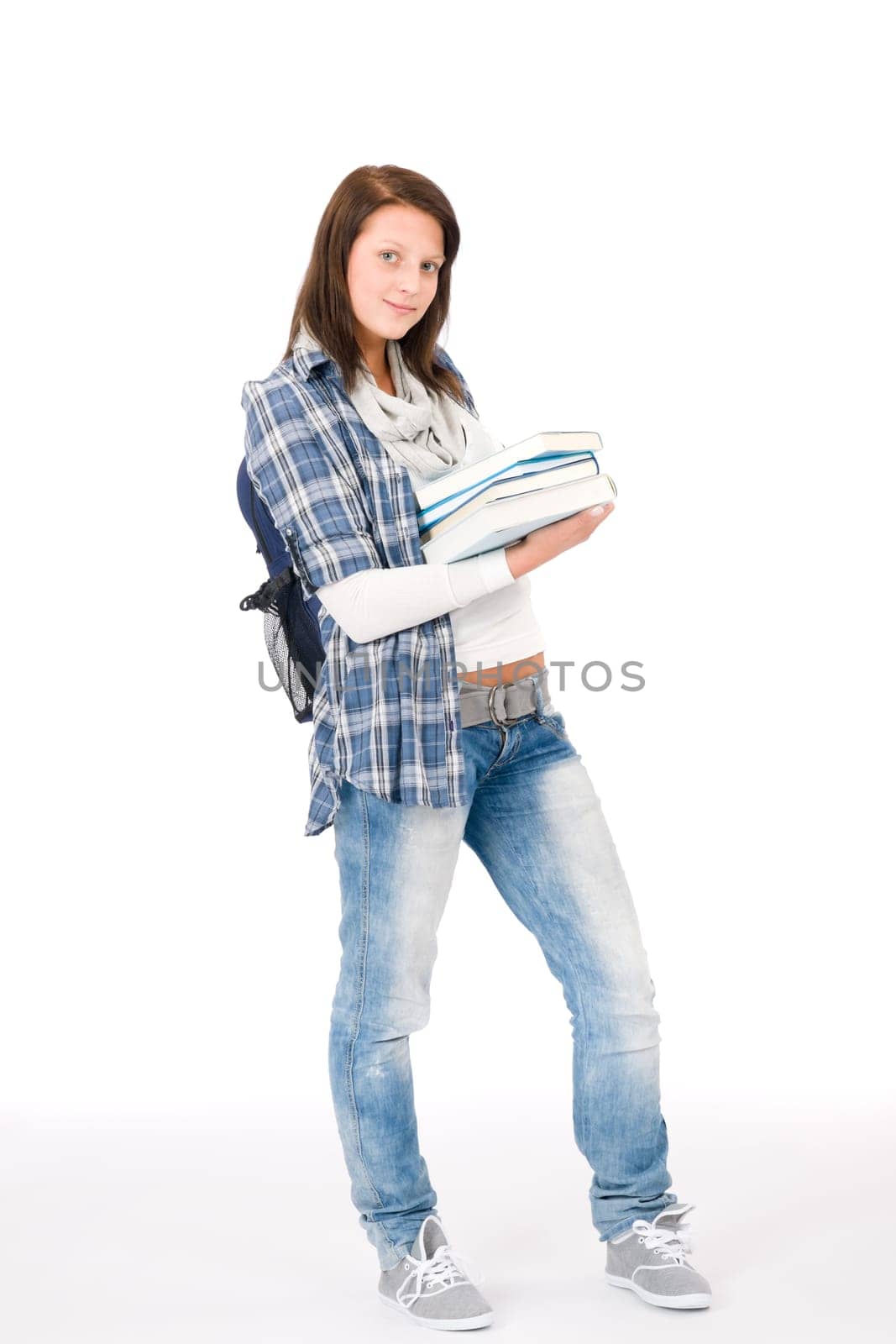 Happy student girl teenager with schoolbag holding books on white