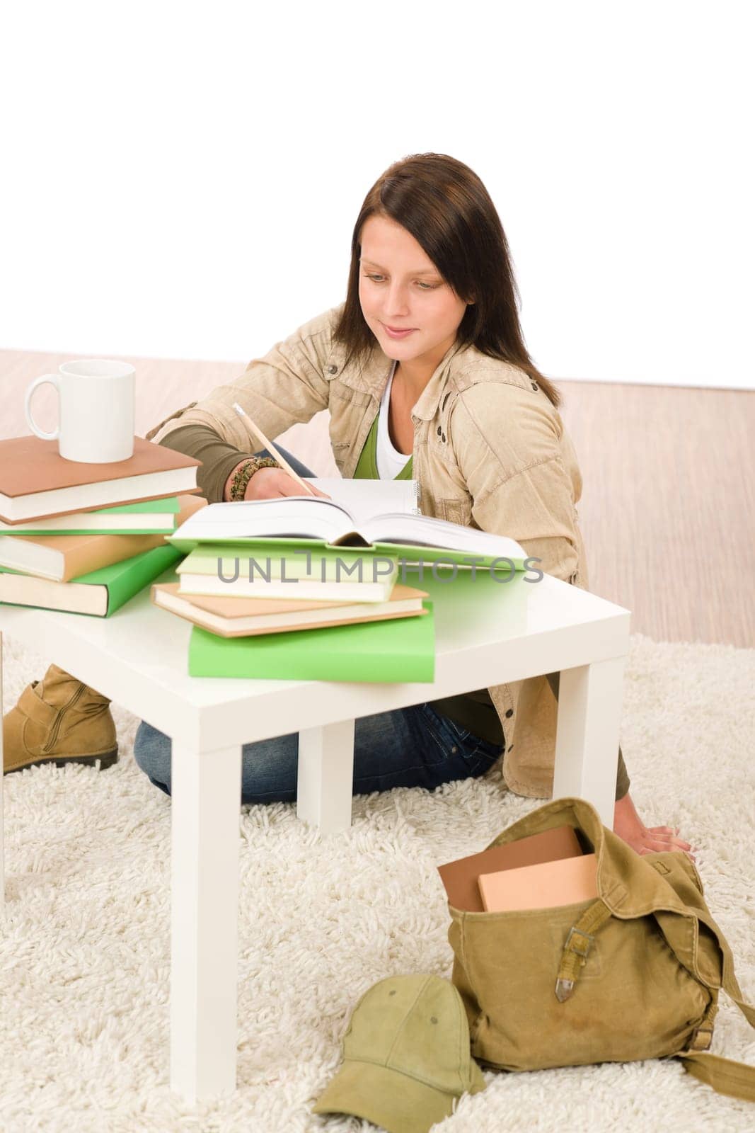 Student girl studying home sitting on floor with books