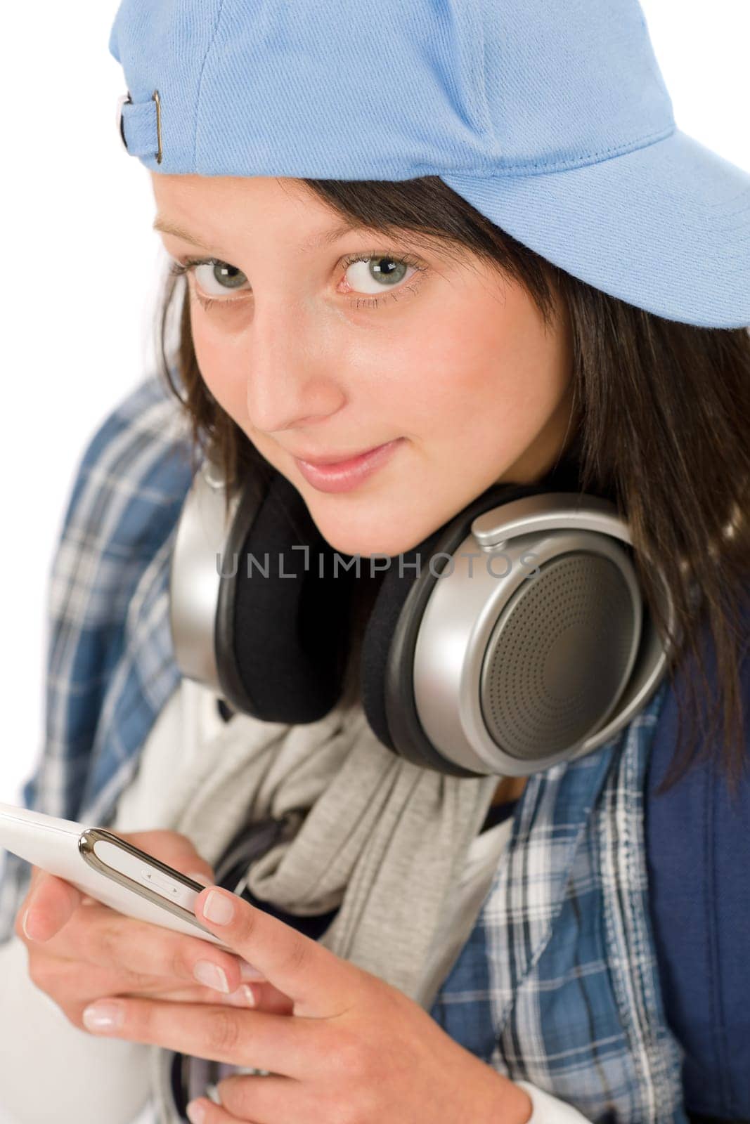 Smiling female teenager enjoy music with headphones dialing on phone