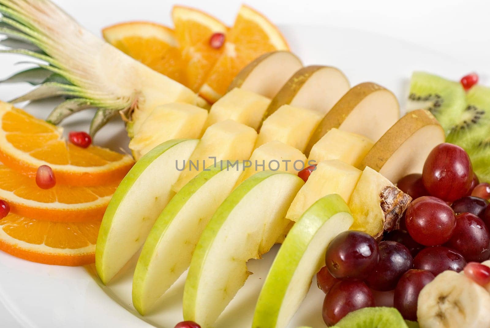 Fruit assortment closeup at plate on a white background