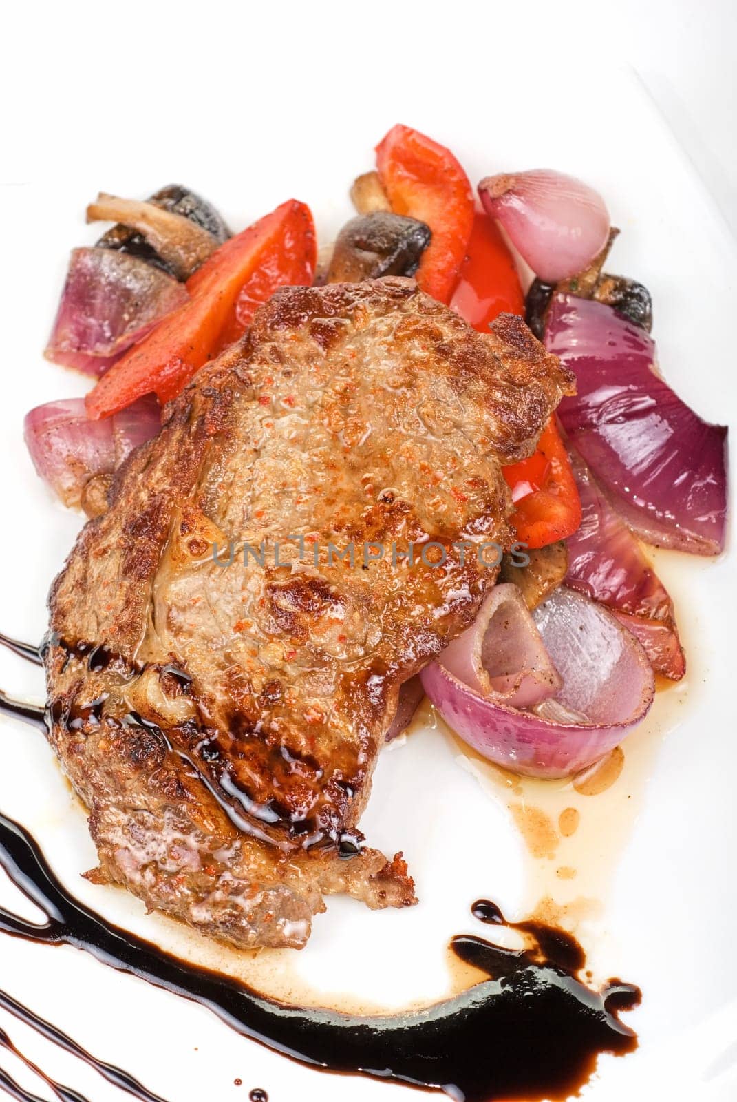 Roasted beef steak with vegetable closeup at plate