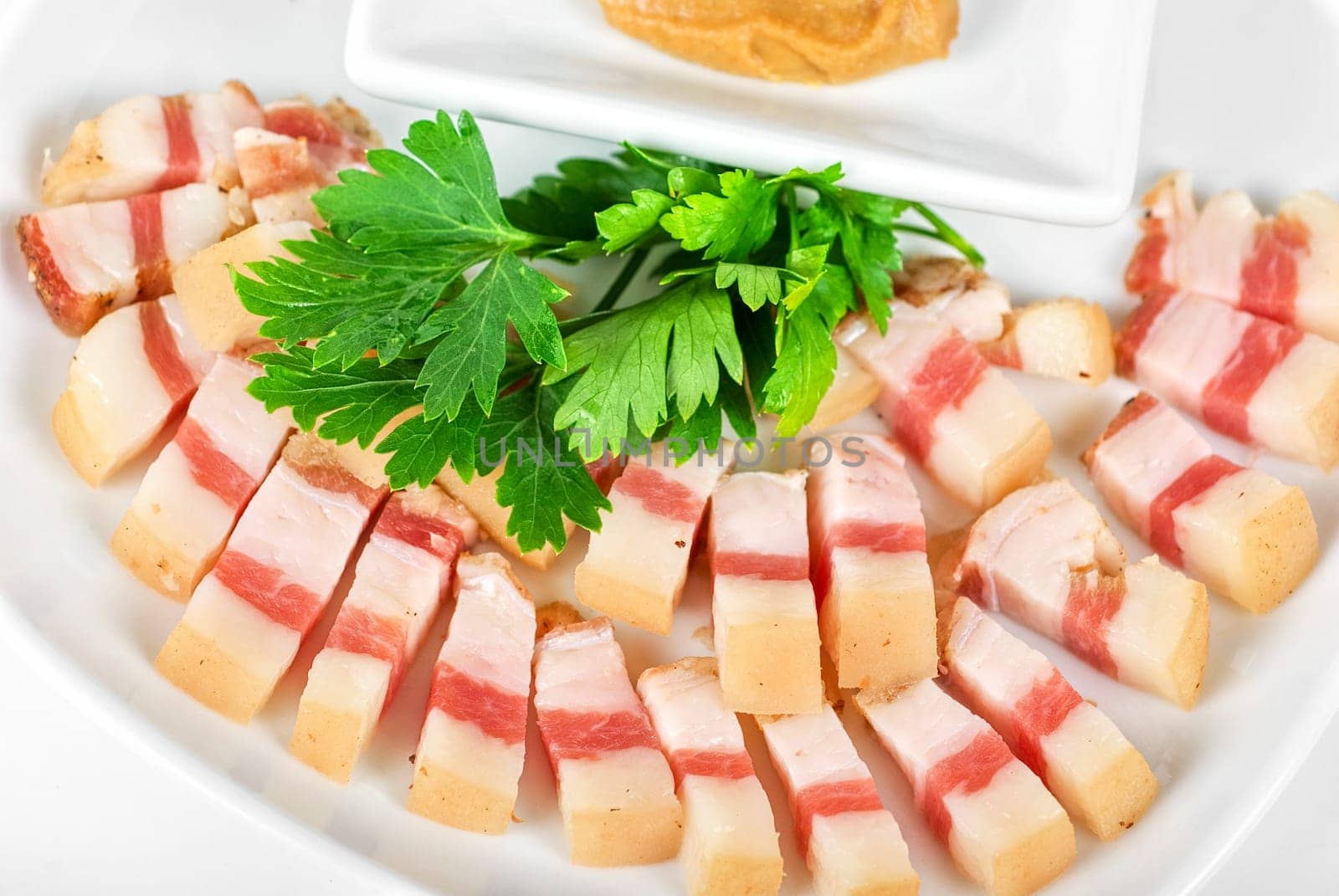 Sliced pig lard with greens closeup