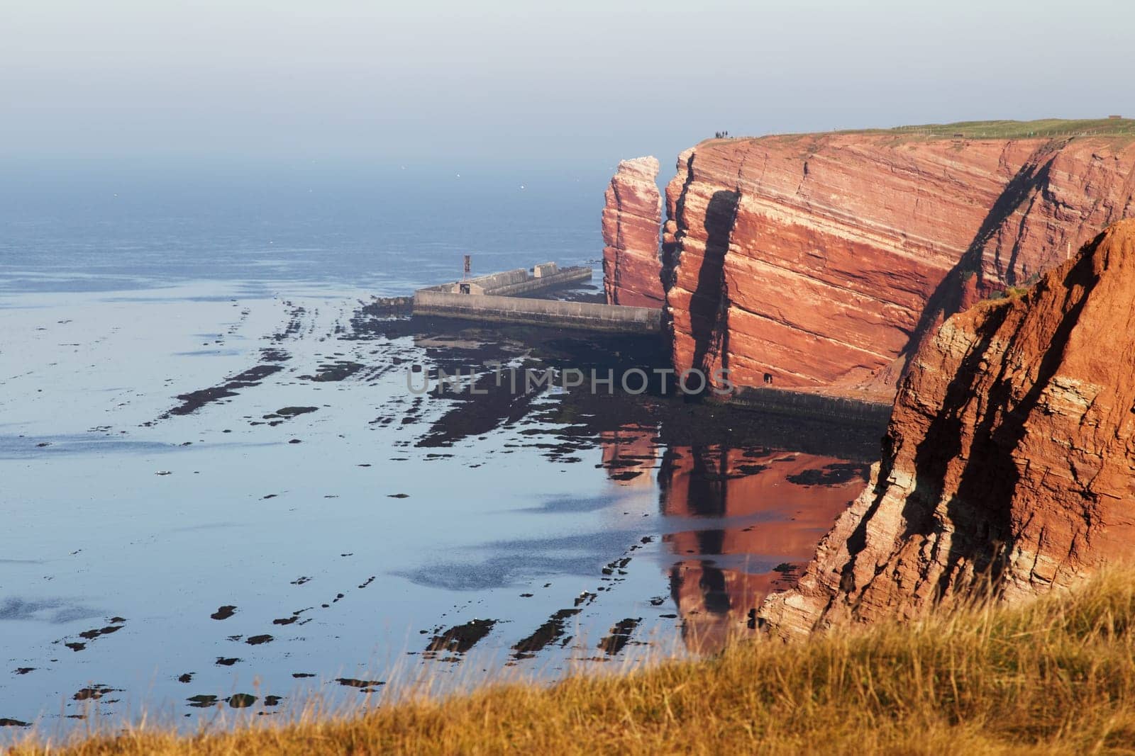 Heligoland's cliffs in the morning light with reflection in the water