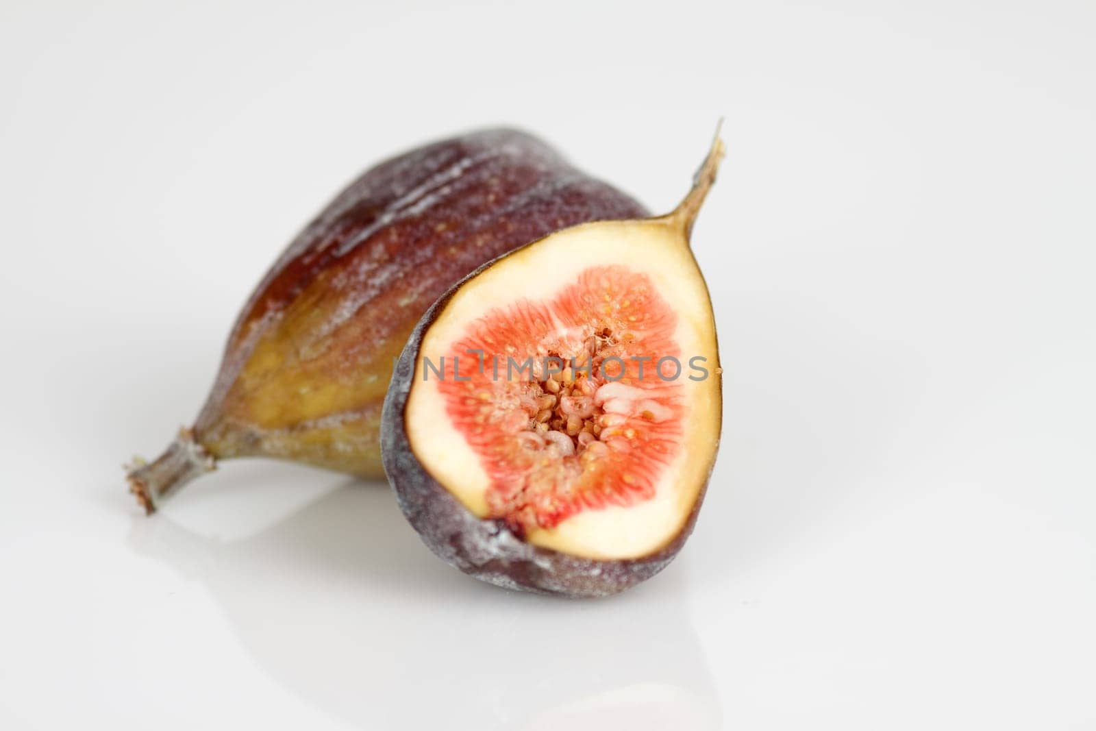 Whole and half figs on a white background