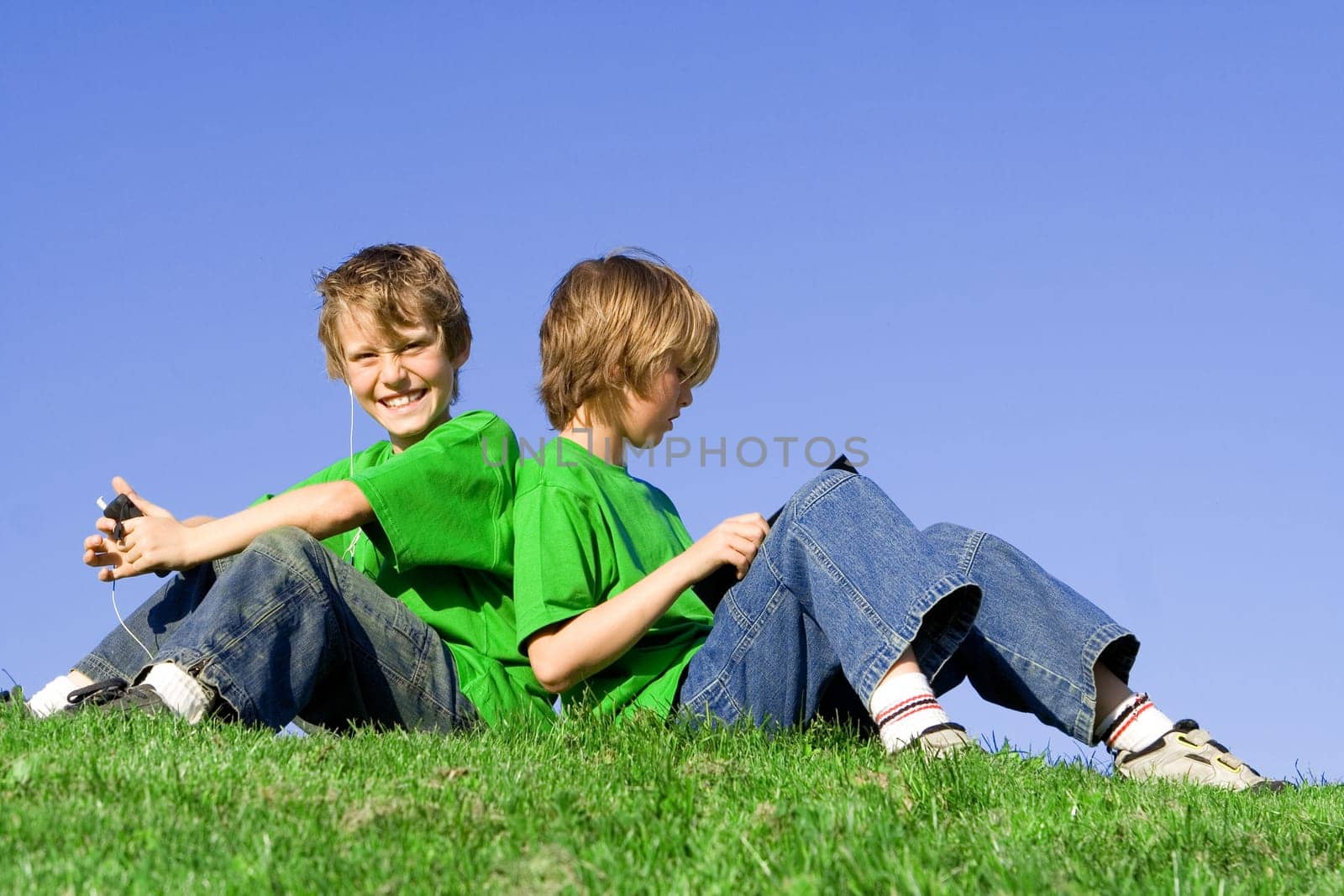 kids outdoors in summer, reading and listening to music