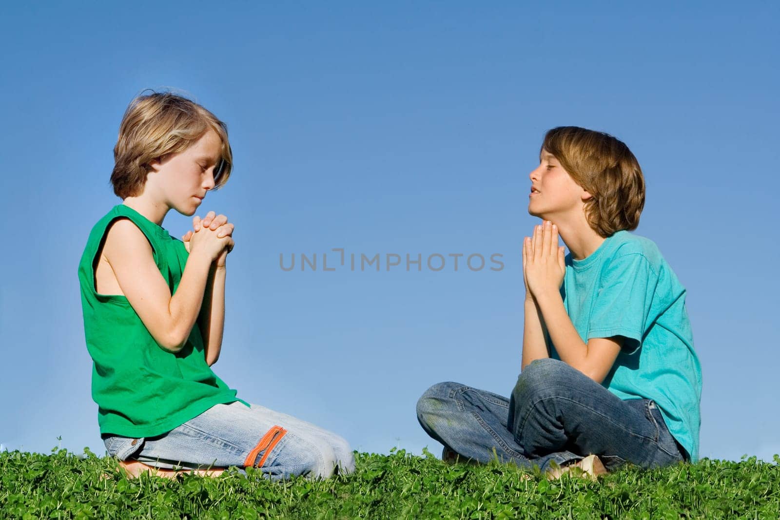 christian children praying outdoors at prayer group or bible camp