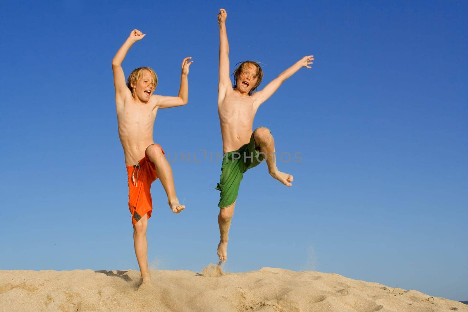 happy kids jumping on summer beach vacation