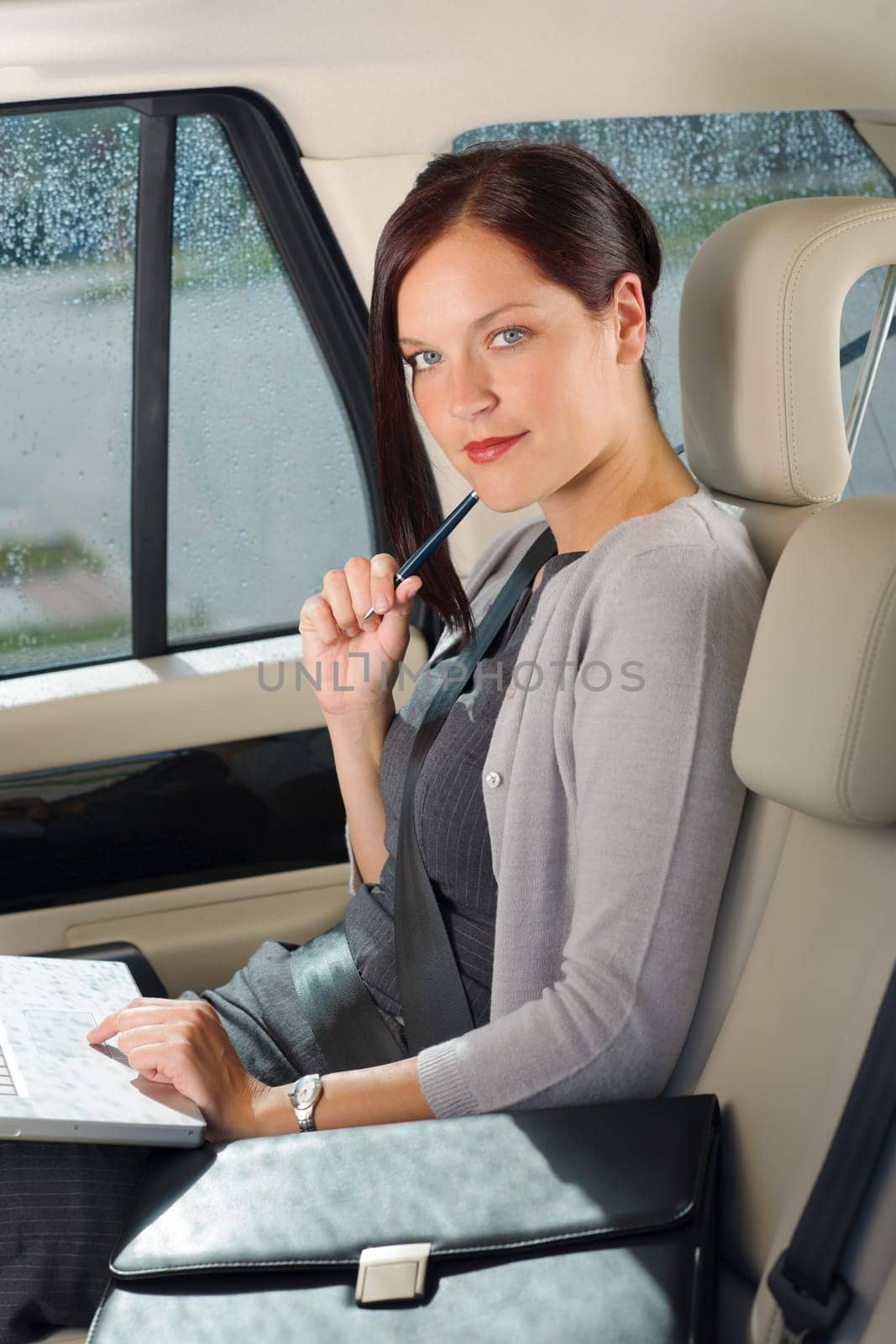 Executive woman manager working on laptop sitting car leather backseat