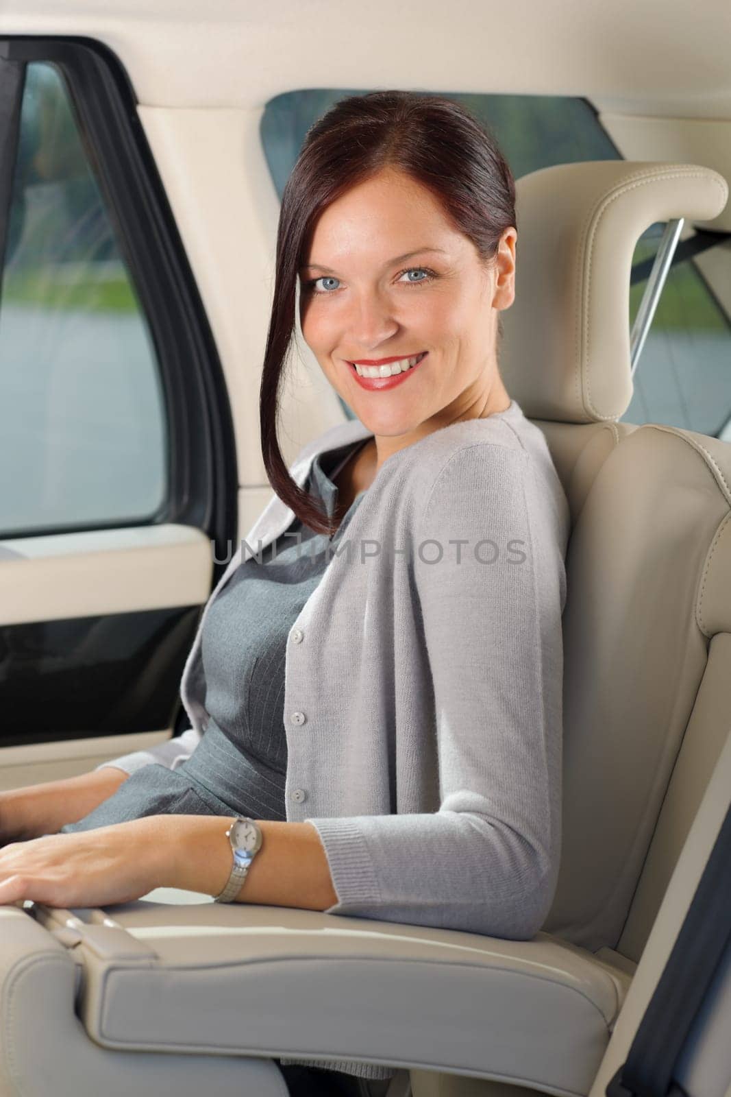 Executive businesswoman sitting in car leather backseat wear suit