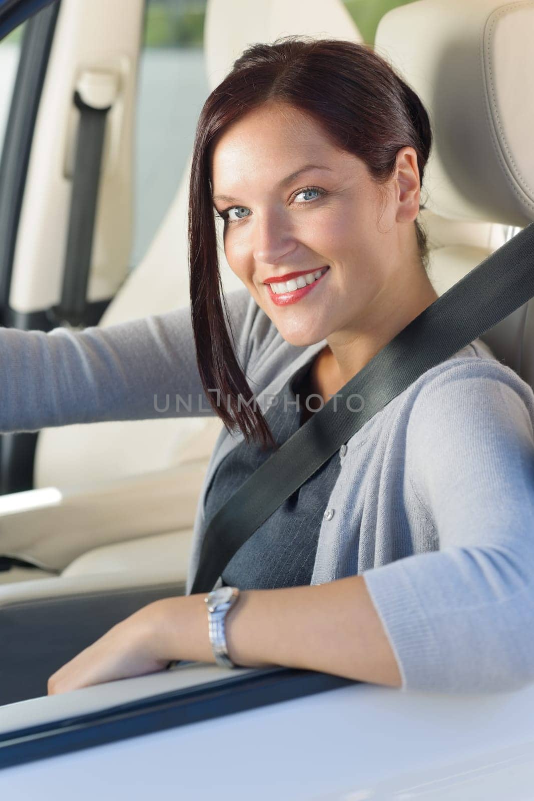 Attractive elegant businesswoman driving luxury new car concentrating