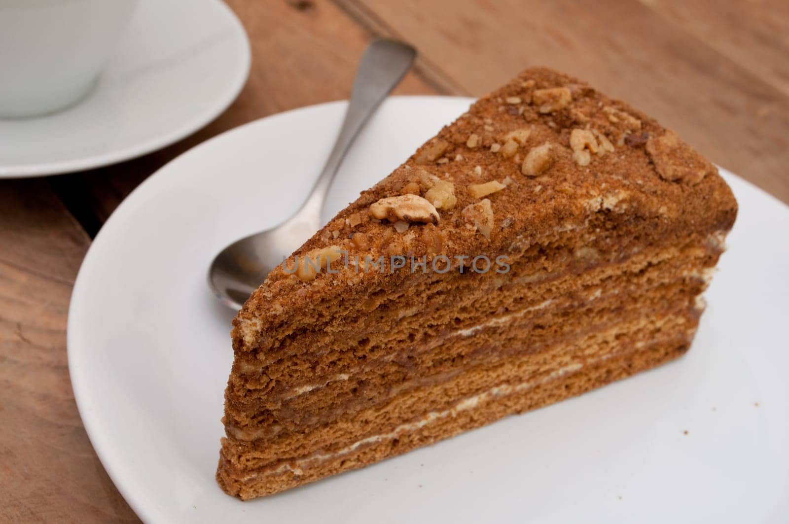 Traditional Honey Cake on Plate and White Cup on Table