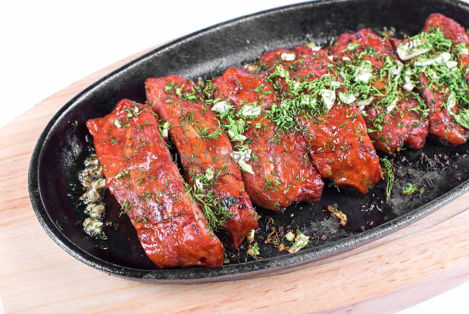 Spare ribs and greens closeup for dinner at pan isolated on a white