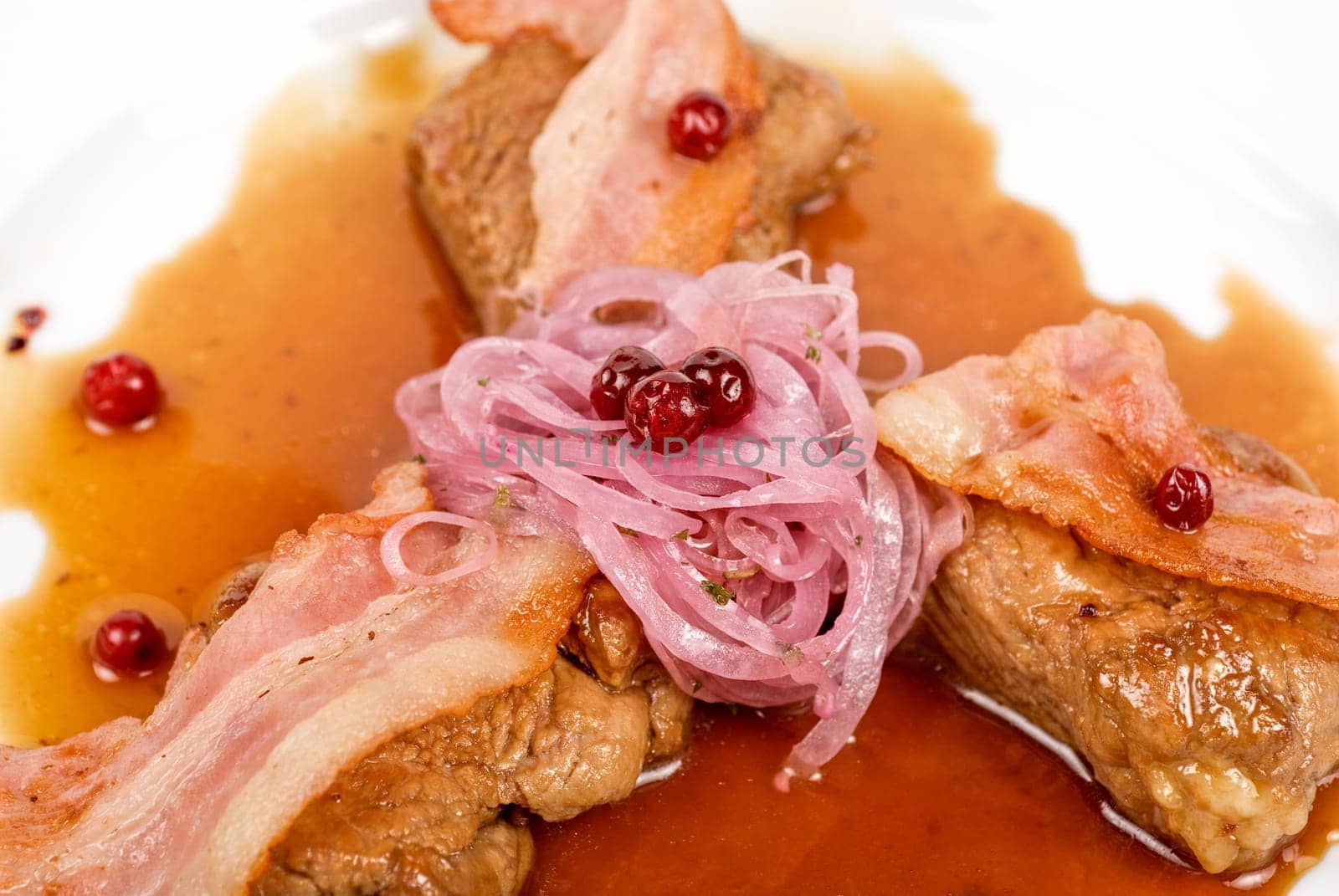 Roast pork meat with bacon, onion and cranberries